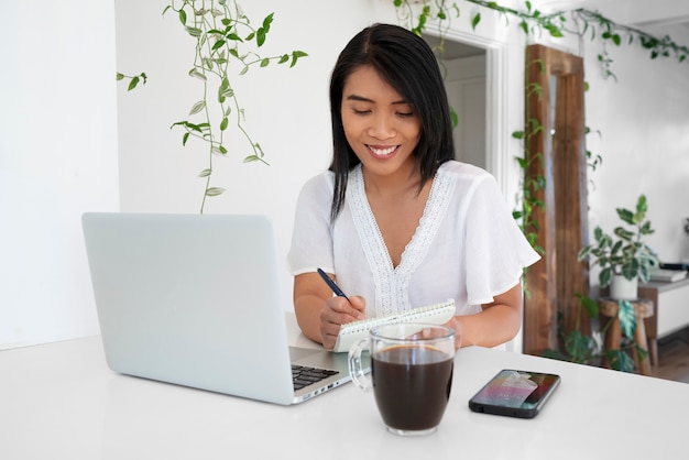 Young woman using laptop and having a cup of coffee