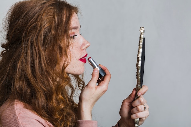 Free Photo young woman using a lipstick