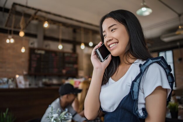 Young woman using and looking at smartphone with feeling happy