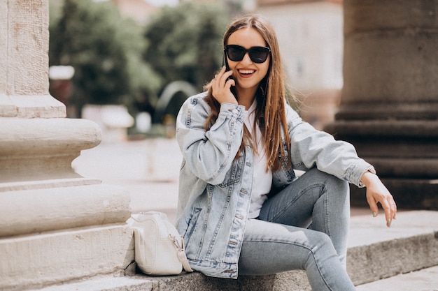 Free photo young woman using phone outside the city