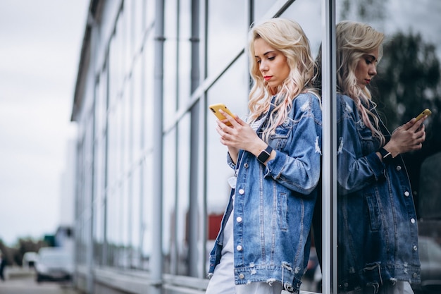 Free photo young woman using phone outside