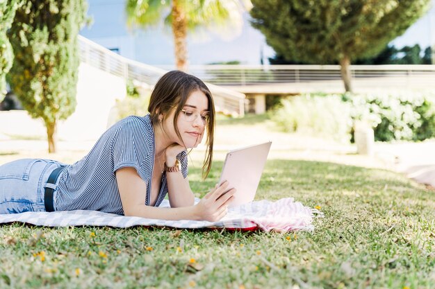 Young woman using tablet in park