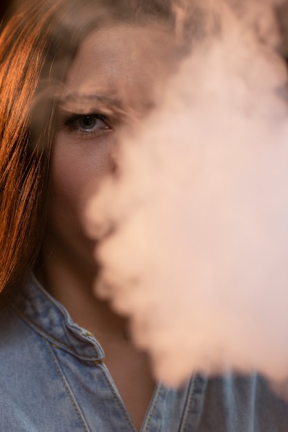 Young woman vaping from a hookah in a bar