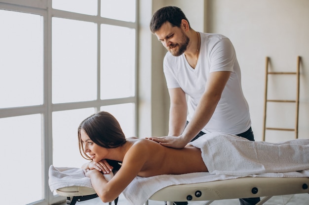 Young woman visiting masseur at spa center