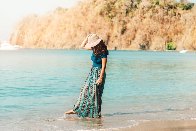 Young woman walking along empty beach