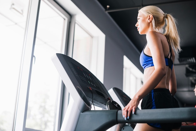 Young woman walking on treadmill