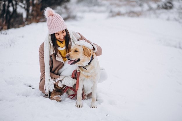 Free Photo young woman walking with her dog in a winter park