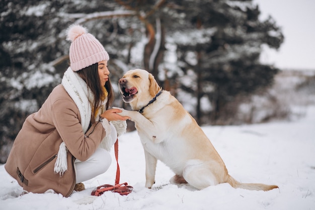 Free Photo young woman walking with her dog in a winter park