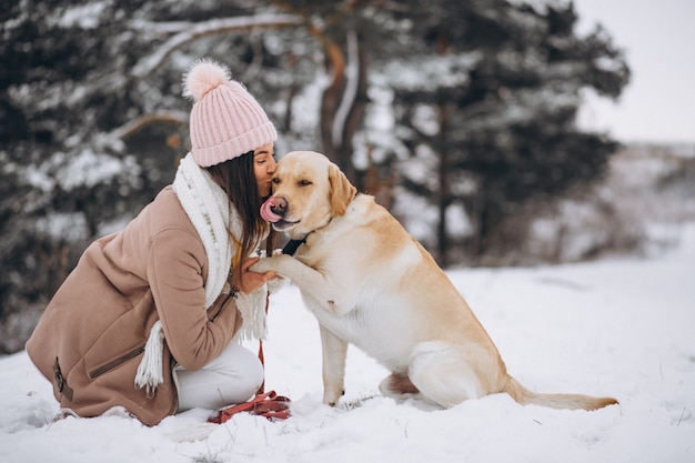 Free photo young woman walking with her dog in a winter park