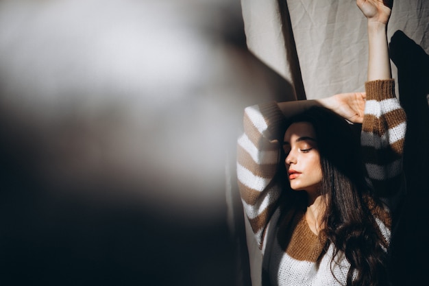 Free photo young woman in a warm sweater sitting on ground