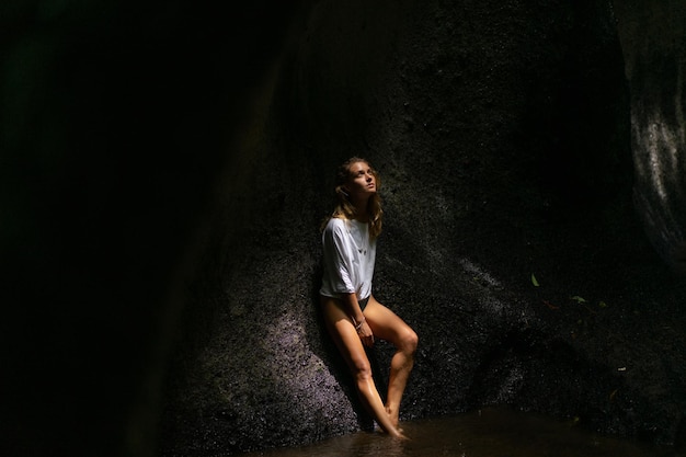 Free photo young woman at the waterfall in the rock bali indonesia