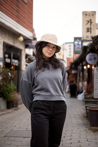 Free photo young woman wearing a bucket hat in the city