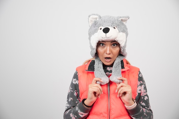 Free Photo young woman wearing funny hat on a white wall.