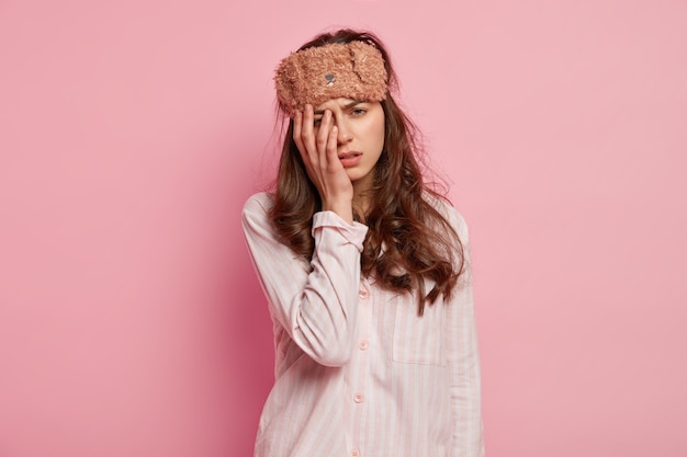 Young woman wearing pajamas and sleep mask