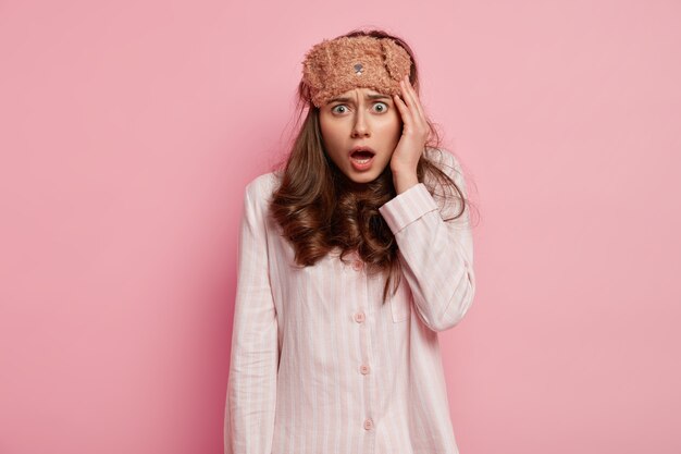 Young woman wearing pajamas and sleep mask