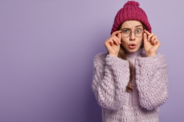 Young woman wearing purple sweater and hat