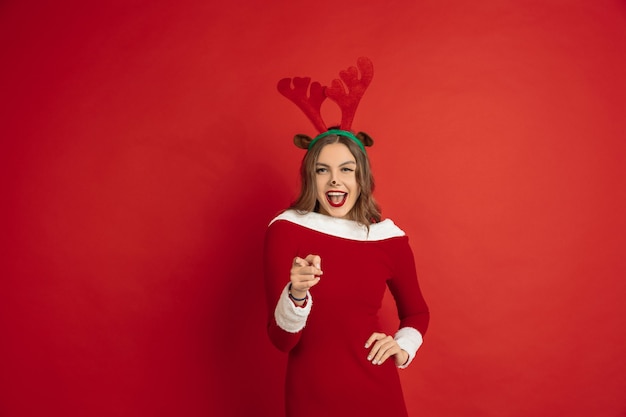 Free Photo young woman wearing a santa dress on red background