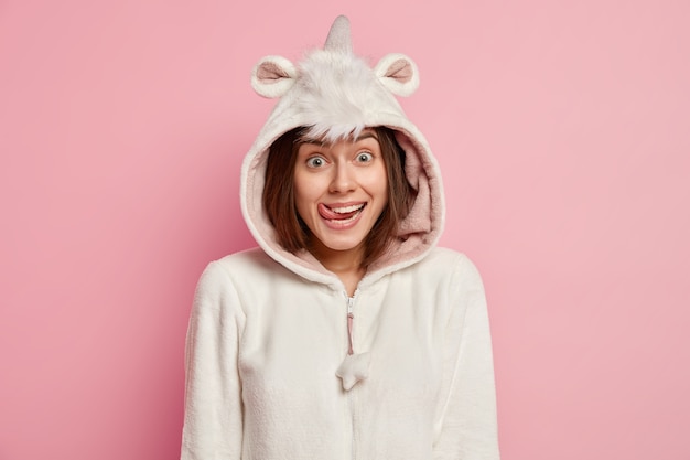 Free photo young woman wearing unicorn pajamas