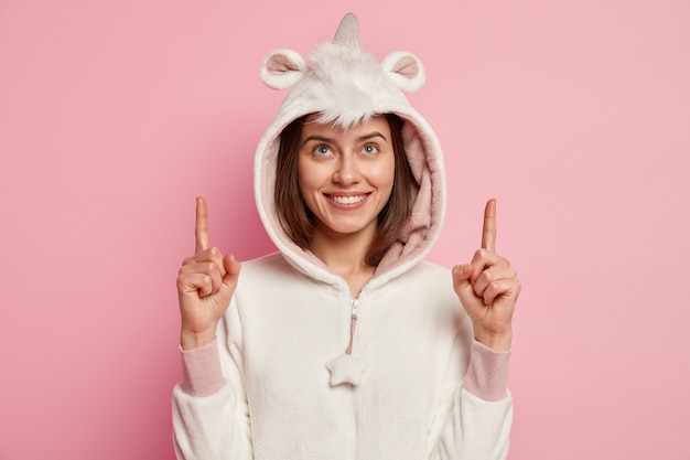 Free photo young woman wearing unicorn pajamas