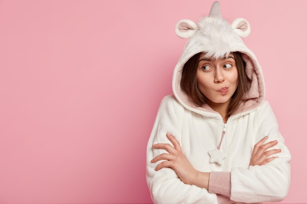 Free photo young woman wearing unicorn pajamas