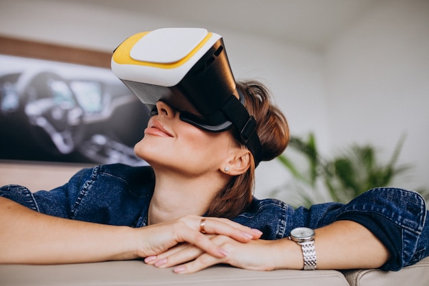 Free photo young woman wearing vr glasses and watching virtual game