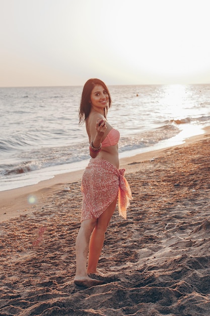 Free photo young woman wearing white bikini posing over sea view at tropical beach