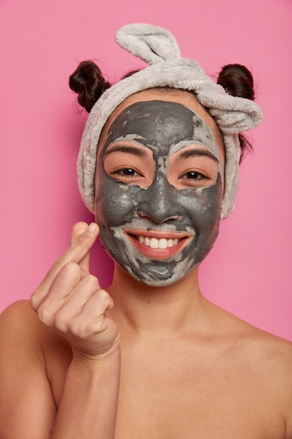 Young woman wears natural facial clay mask skin treatments after taking bath