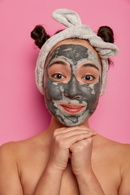 Young woman wears natural facial clay mask skin treatments after taking bath