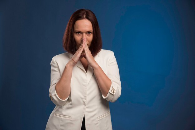 Young woman in white blazer looks smart.