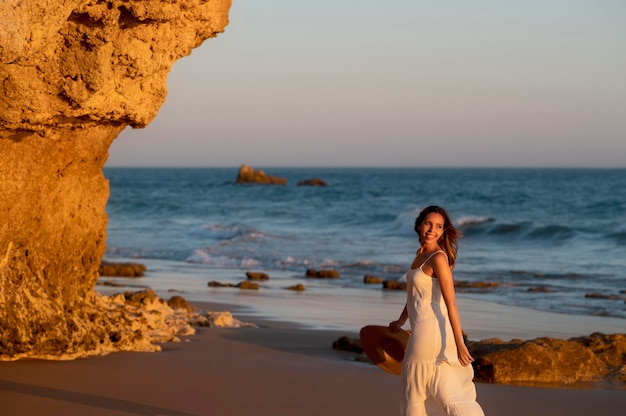 Young woman in a white dress next to the sea