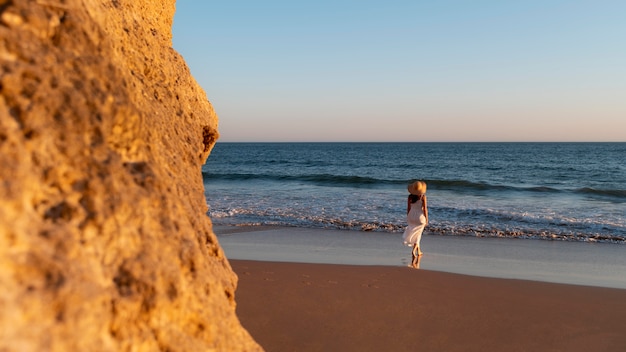 Free photo young woman in a white dress next to the sea