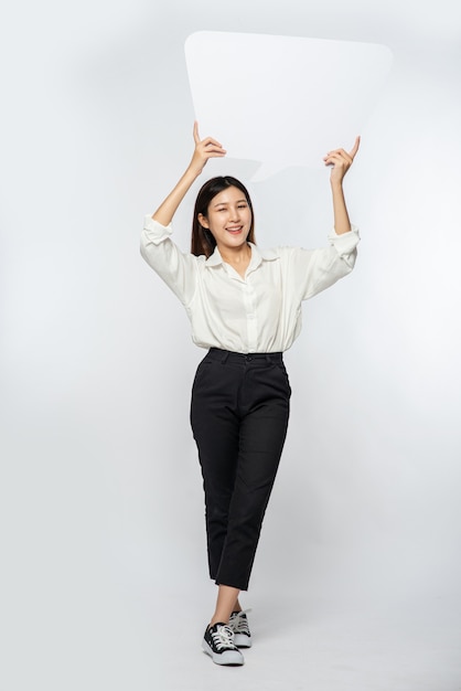 A young woman in a white shirt holding a thought box symbol