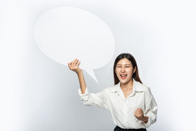 A young woman in a white shirt holding a thought box symbol