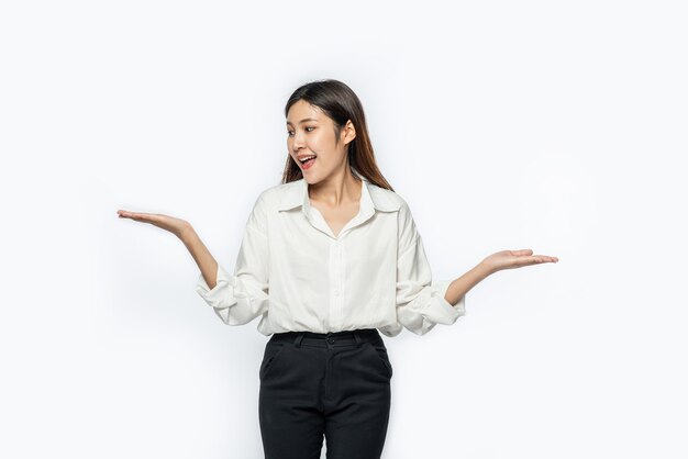 A young woman in a white shirt and spreading both hands