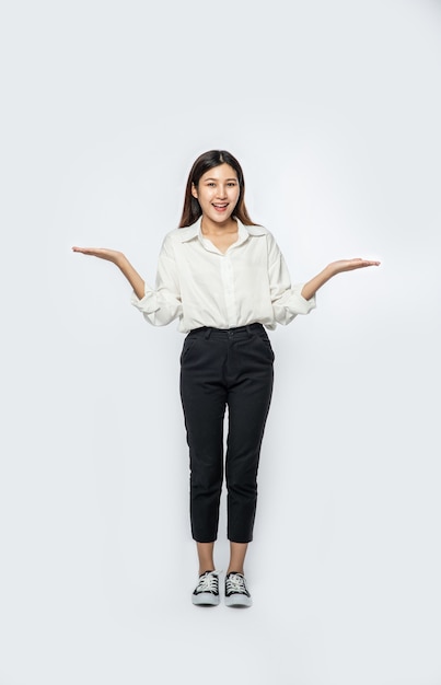 A young woman in a white shirt and spreading both hands