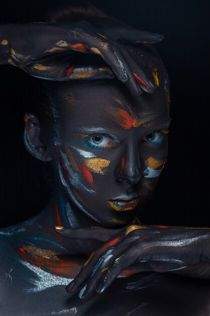 young woman who is posing covered with  black paint