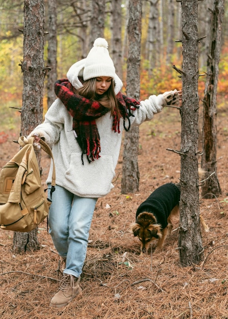 Free photo young woman in winter clothes with her dog