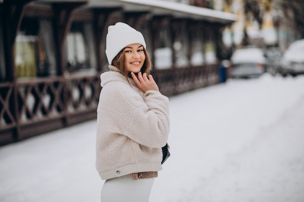 Free photo young woman in winter outfit outside the street