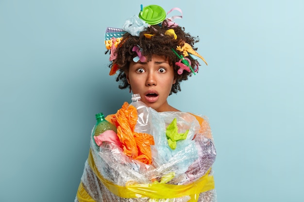 Free Photo young woman with afro haircut holding bag with plastic waste