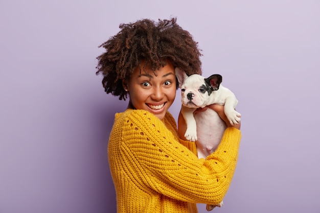 Free Photo young woman with afro haircut holding puppy