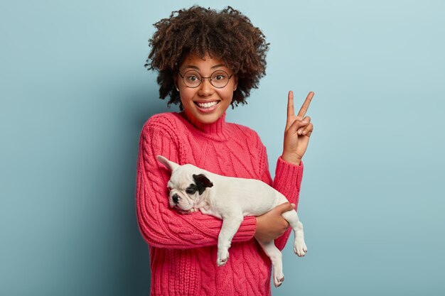 Young woman with Afro haircut holding puppy