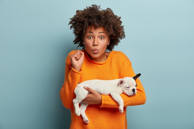 Free Photo young woman with afro haircut holding puppy