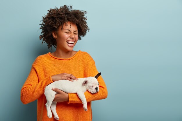 Young woman with Afro haircut holding puppy