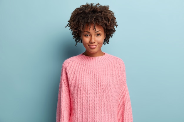 Free photo young woman with afro haircut wearing pink sweater