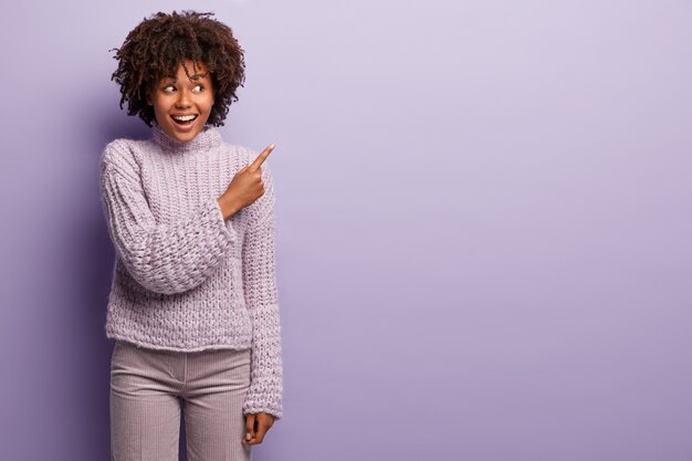 Young woman with Afro haircut wearing purple sweater