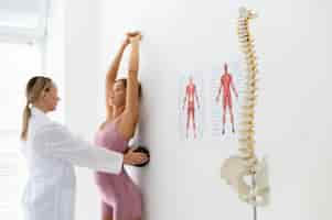 Free photo young woman with back problems doing a physiotherapy treatment