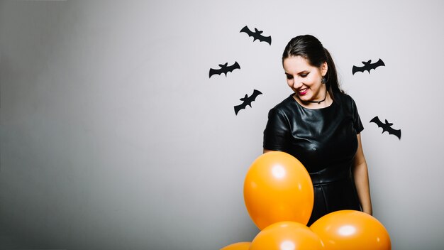 Young woman with balloons and bats