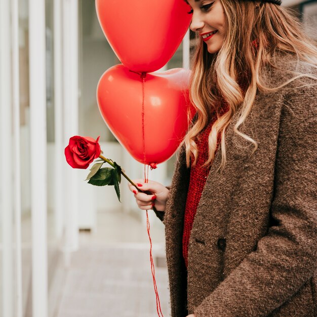 Young woman with baloons and roses