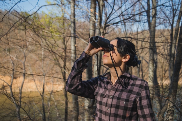 Free Photo young woman with binoculars outdoors