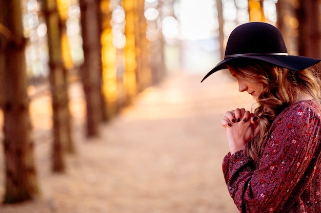 young woman with black hat praying